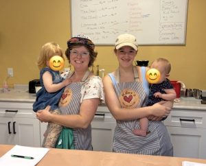 The women who own Mikey's Play Cafe hold their children in front of a snack bar